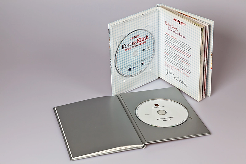 Abbildung zweier außergewöhnlich hochwertige Bücher mit integrierter CD, produziert von der Conzella – Mit Leidenschaft zum Buch