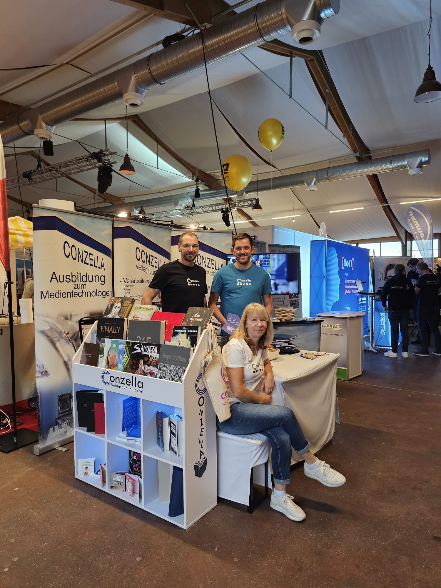 Das Stand Team der Conzella: Maik Schmidt, Alois Osterholzer (stehend, v.l.n.r.) und Anna Henning